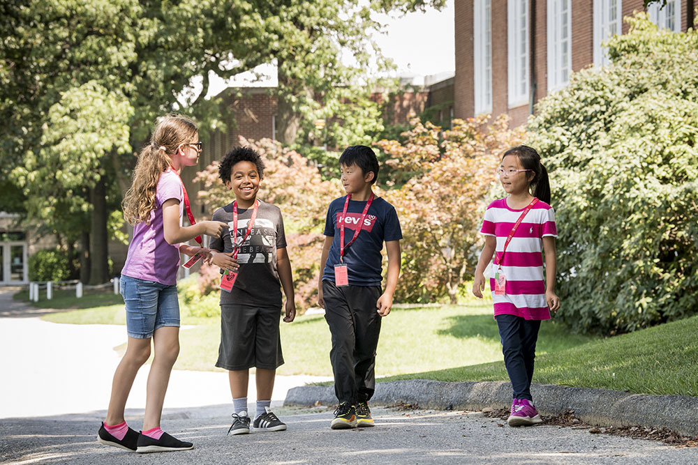 Four CTY students walking on-campus, talking