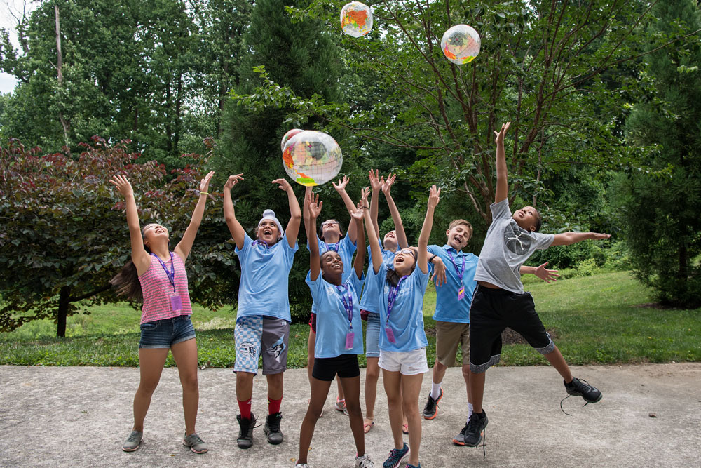 a group of CTY students outdoors playing with blow-up globes