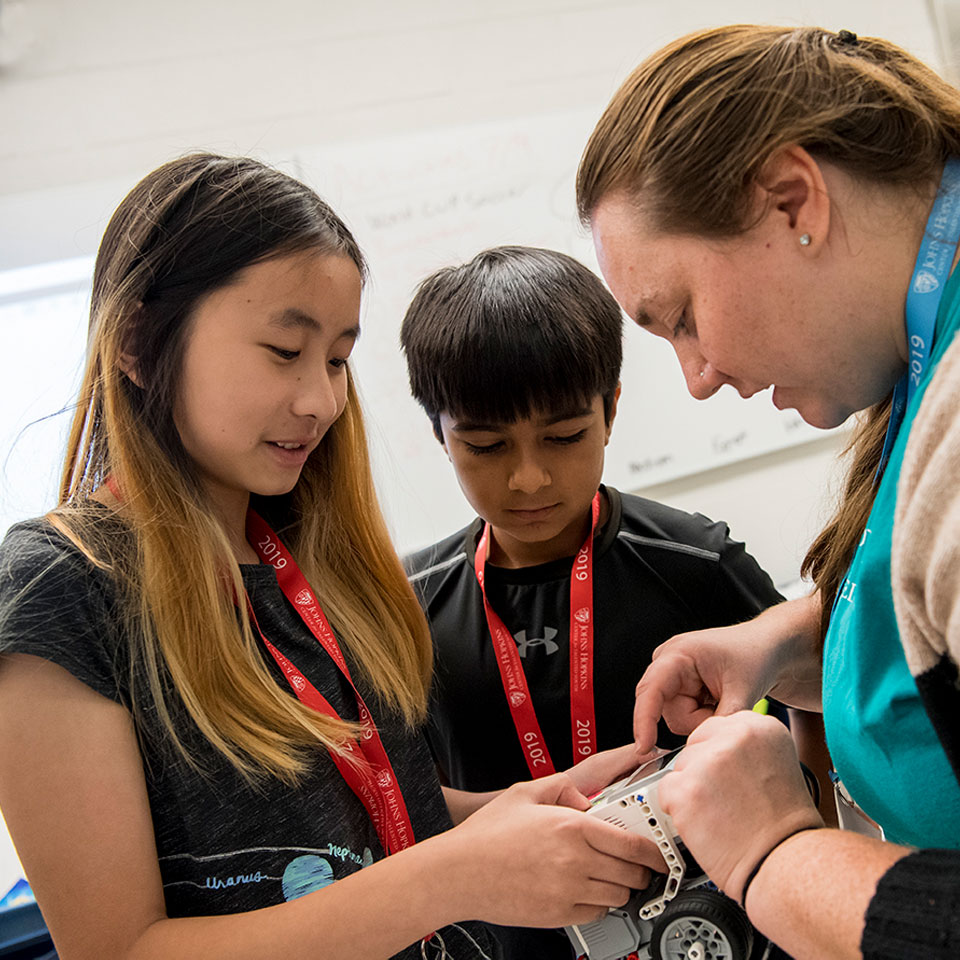 Image of Laya Theberge, a CTY instructor, demonstrating a lesson to two CTY students