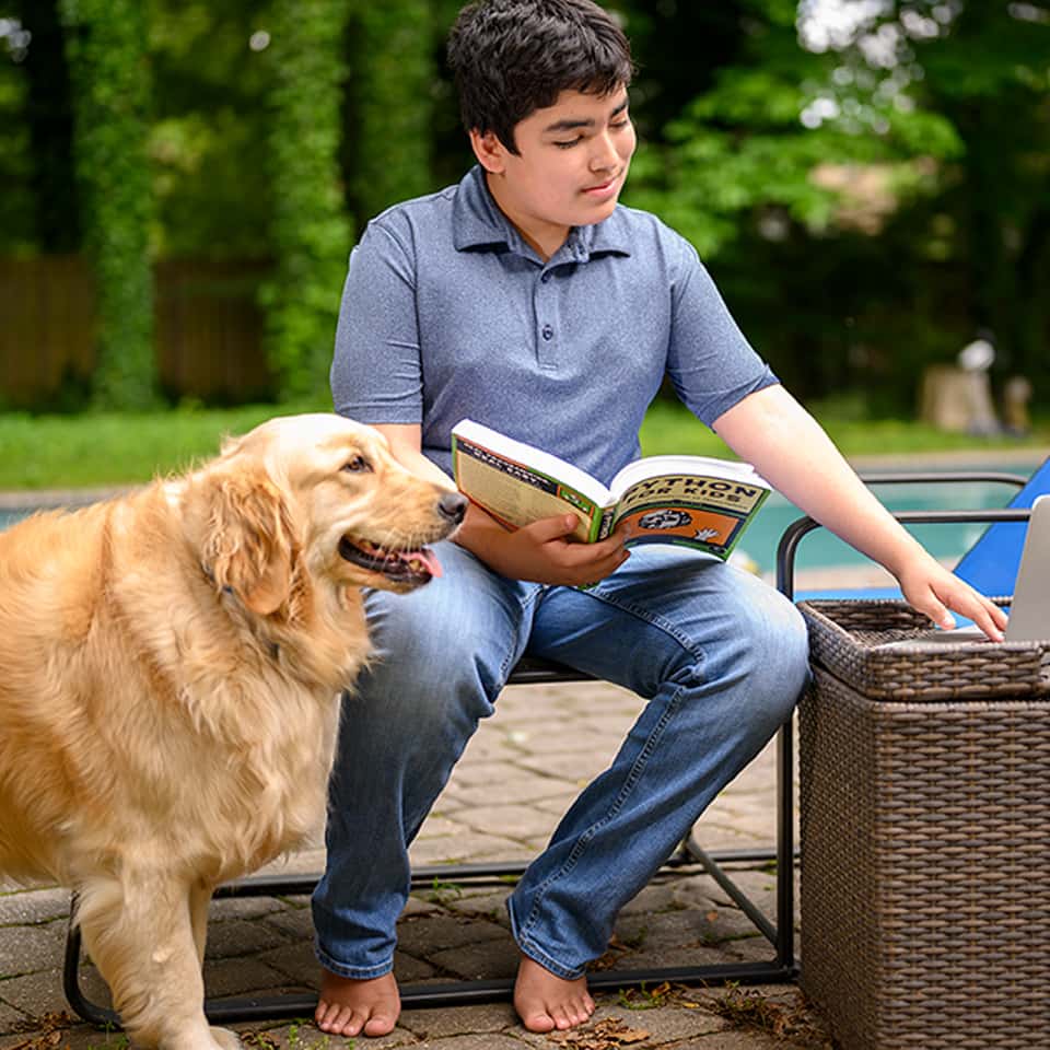 CTY student Jesse R. with dog holding book