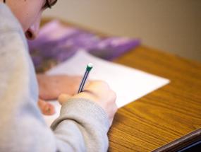 Student taking a test using pencil and paper