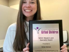 Emily Delinski holding her NAGC award plaque.