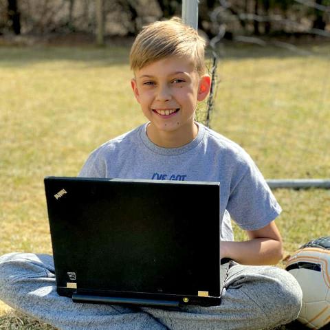 CTY student sitting outside with a laptop