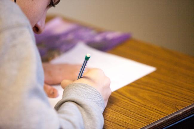 Student taking a test using pencil and paper